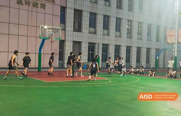 Students at Shenzhen Foreign Languages GBA Academy playing basketball on an outdoor court.