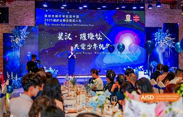 Students and teachers at Shenzhen Foreign Languages GBA Academy attending an evening gala or graduation ceremony with a large screen on the stage.