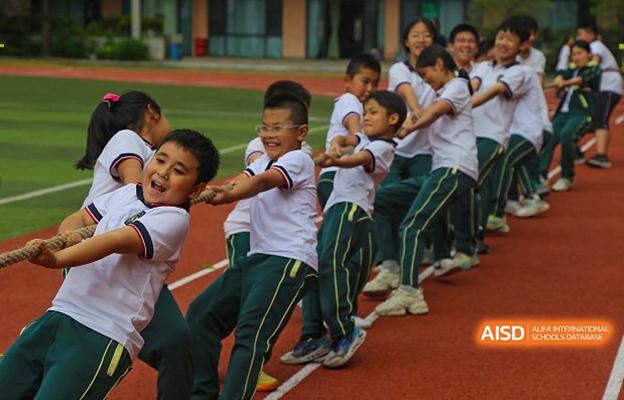A group of smiling students at Shenzhen Foreign Languages GBA Academy participating in a tug-of-war game.