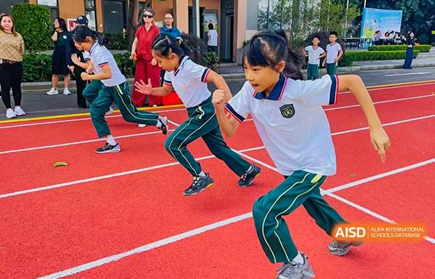 A close-up of a group of students at Shenzhen Foreign Languages GBA Academy running on a red track during a sports day.