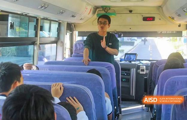 A bus driver at Shenzhen Foreign Languages GBA Academy checking on students on a school bus.