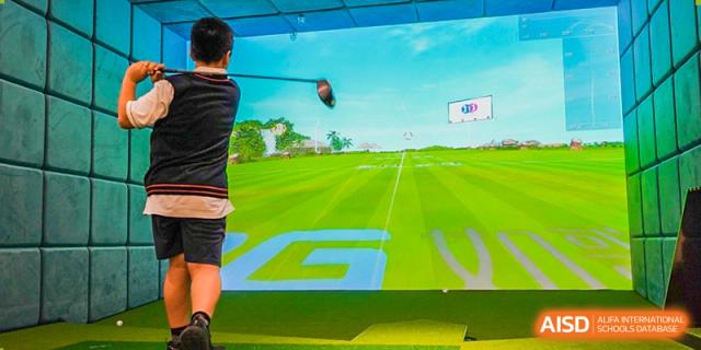 A student at Shenzhen Foreign Languages GBA Academy practicing golf on an indoor simulator with an instructor.