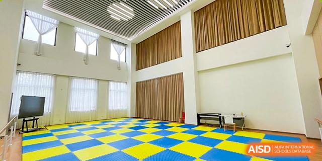 An empty, colorful practice room with yellow and blue mats on the floor at Shenzhen Foreign Languages GBA Academy.