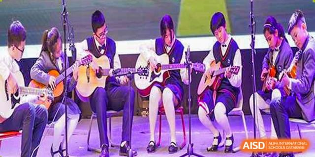 Students at Shenzhen Foreign Languages GBA Academy performing music with guitars and other instruments on a stage.