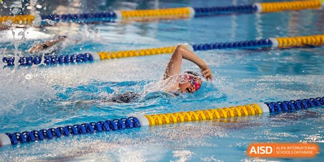 A student at Shenzhen Foreign Languages GBA Academy swimming freestyle in a lane during a race.