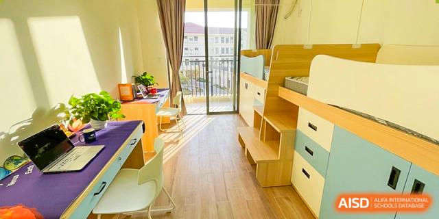 A bright and sunny student dormitory room with a bunk bed and desk at Shenzhen Foreign Languages GBA Academy.