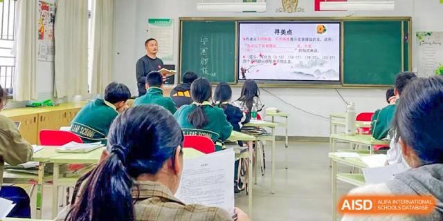 A teacher from Maple Leaf International Academy Shenzhen is standing in front of a smart board, teaching a class.