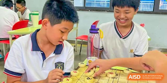 A close-up shot of two students from Maple Leaf International Academy Shenzhen playing Chinese chess.