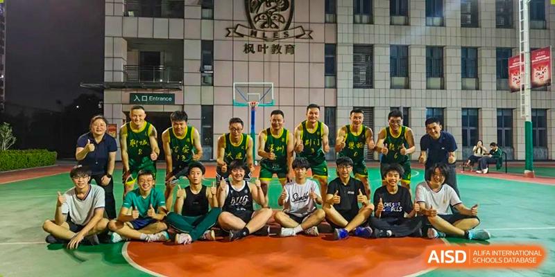 A group of male students from Maple Leaf International Academy Shenzhen are posing for a group photo in their basketball jerseys on a basketball court.