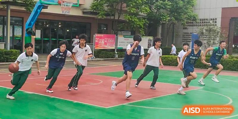 Three male students from Maple Leaf International Academy Shenzhen are running and playing on a sports court.