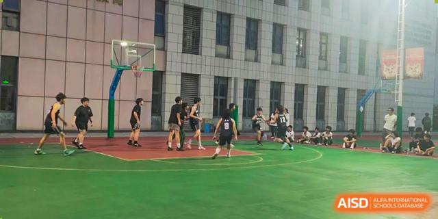Students from Maple Leaf International Academy Shenzhen are playing basketball on a sports court.