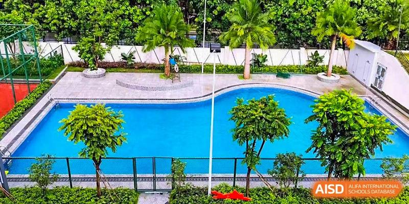 A close-up shot of the swimming pool and surrounding greenery at Maple Leaf International Academy Shenzhen.