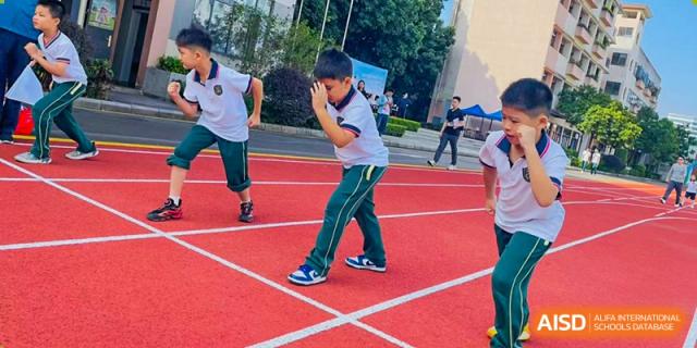 Students from Maple Leaf International Academy Shenzhen are participating in a running race on an outdoor track.