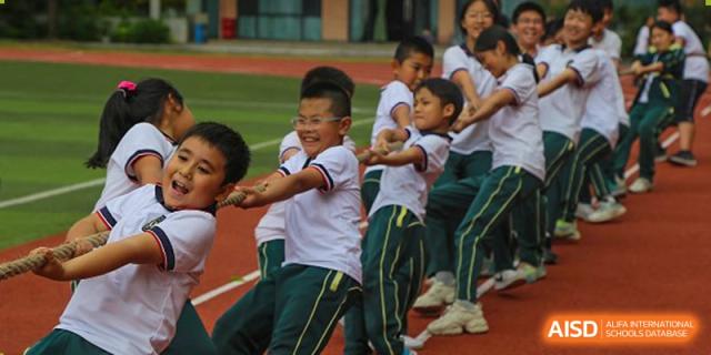 Students from Maple Leaf International Academy Shenzhen are playing tug-of-war during a sports event.
