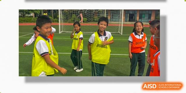 A student from Maple Leaf International Academy Shenzhen is smiling while wearing a yellow bib during a sports activity on a soccer field.