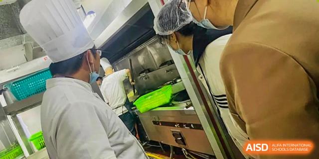 A close-up shot of a kitchen staff member at Maple Leaf International Academy Shenzhen preparing a meal.