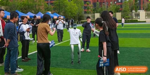 A student at HuZ Deutsche Schule Shenyang interacting with a robot on a sports field.