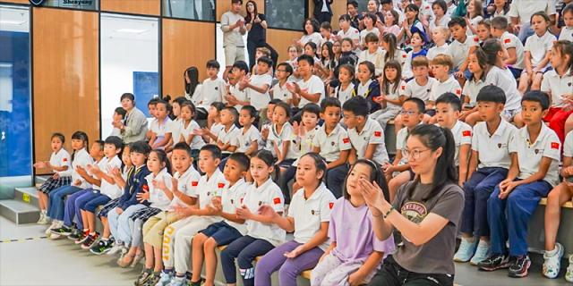Students at HuZ Deutsche Schule Shenyang sitting in an audience and watching a performance.