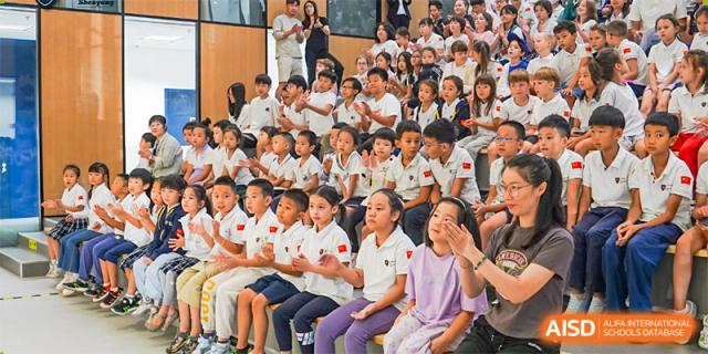 Students at HuZ Deutsche Schule Shenyang sitting in an audience and watching a performance.