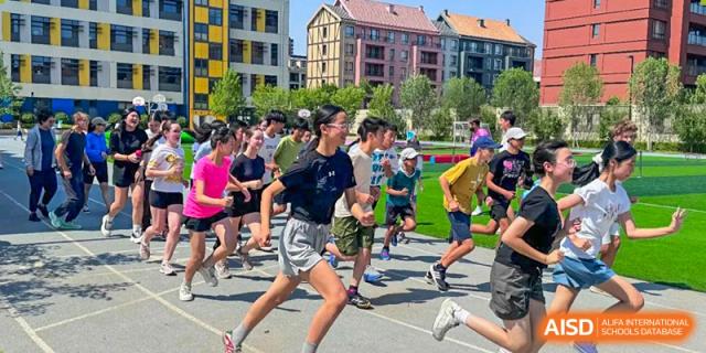 Students are participating in a running race on a track at HuZ Deutsche Schule Shenyang.