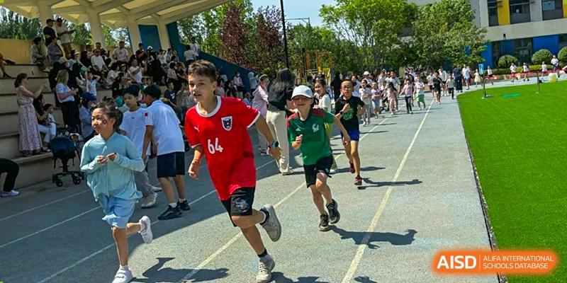 Students are participating in a running race on a track at HuZ Deutsche Schule Shenyang.