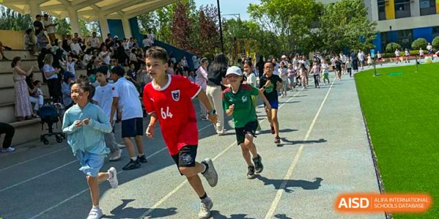 Students are participating in a running race on a track at HuZ Deutsche Schule Shenyang.