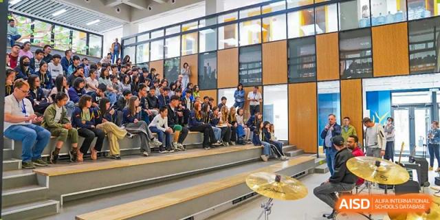An audience of students and faculty at HuZ Deutsche Schule Shenyang seated for a school performance.