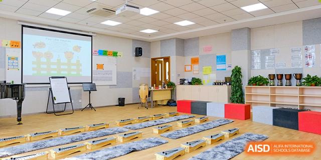 A wide view of a classroom at Overseas Chinese Academy of Chiway Suzhou with cushions laid out on the floor.
