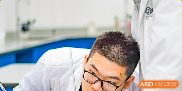 A close-up of a male student from Overseas Chinese Academy of Chiway Suzhou with his head tilted down.