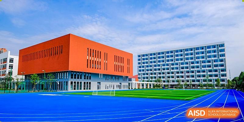 An exterior shot of the sports track and modern buildings at Overseas Chinese Academy of Chiway Suzhou.