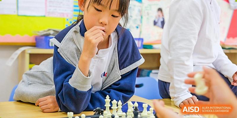 A young student from Overseas Chinese Academy of Chiway Suzhou thinking during a chess game.