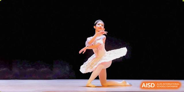 A female student from Overseas Chinese Academy of Chiway Suzhou performing ballet on a stage.