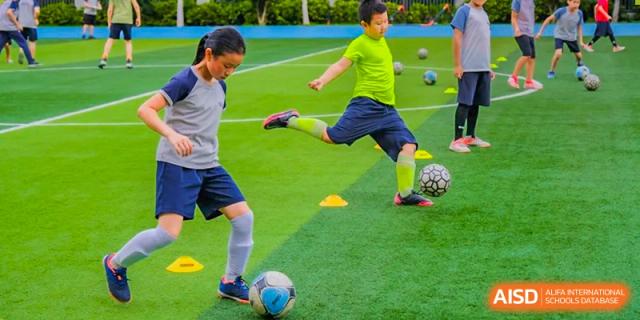 A student from Overseas Chinese Academy of Chiway Suzhou playing soccer on a field.