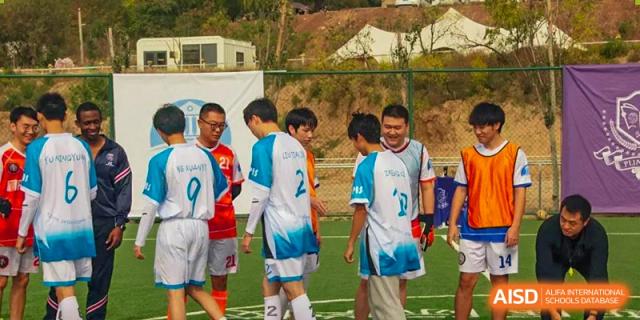 Students in uniforms posing during a break while playing soccer or a team sport at Shanxi Plinth International School.