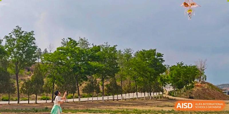 Scenic view of a large, grassy outdoor area or park near the campus of Shanxi Plinth International School.