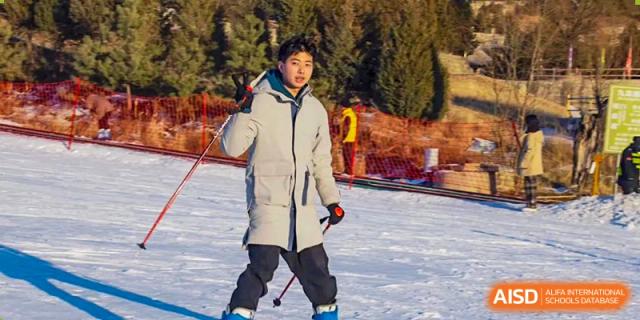 Student standing in the snow or on a slope, dressed for winter activities, at Shanxi Plinth International School.