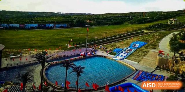 Aerial view of a recreational water area or small lake with boats near the campus of Shanxi Plinth International School.