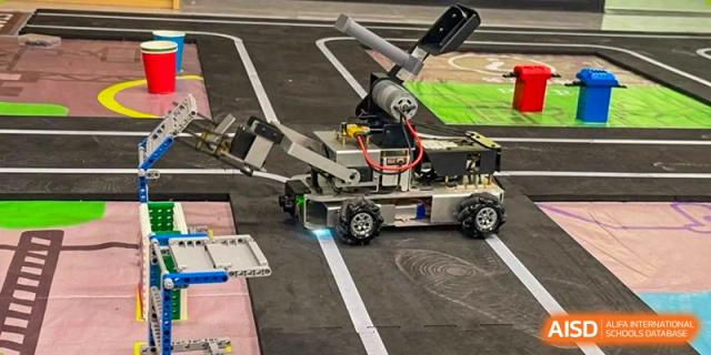 A small, wheeled robot on a track, showing a robotics class at Wuxi Boston International School.