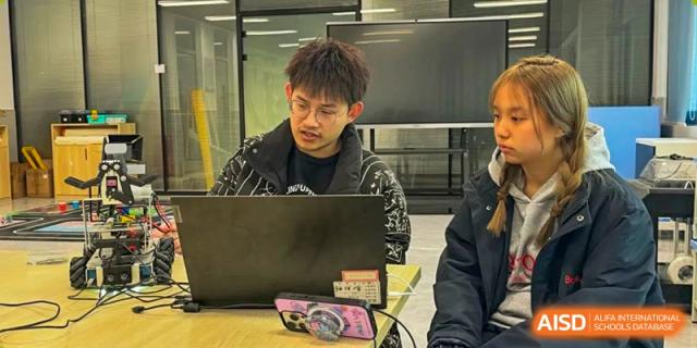 A male student working intently on a laptop computer at Wuxi Boston International School.