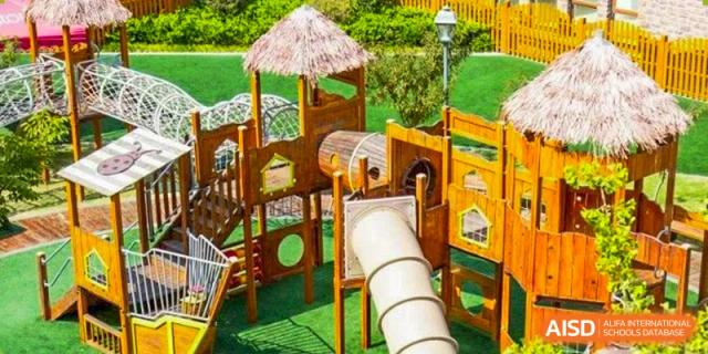 A wooden outdoor playground with a slide and thatched roof structure at Wuxi Boston International School.