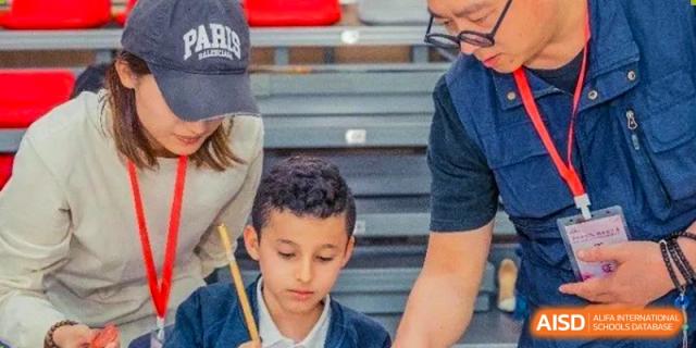 Young male student concentrating intently during an activity at Wuxi Boston International School.