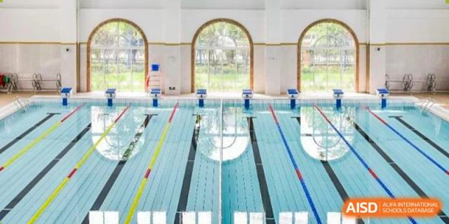 Indoor swimming pool facility with multiple lanes and large arched windows at Wuxi Boston International School.