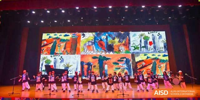 Students performing a dance or theatrical act on a colorful stage at Wuxi Boston International School.