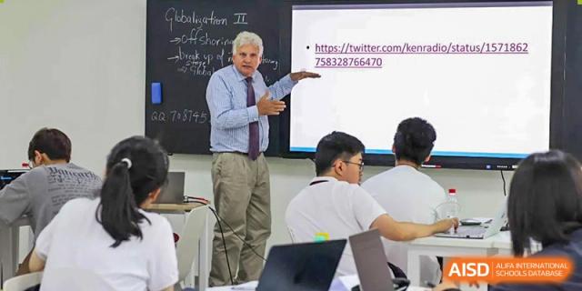 A teacher stands by a student, holding up a paper in a close-up of a classroom setting at Wuhan Britain-China School.