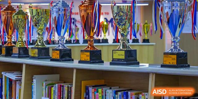 A shelf holding several trophies and medals, signifying awards won in academics or sports by Wuhan Britain-China School.