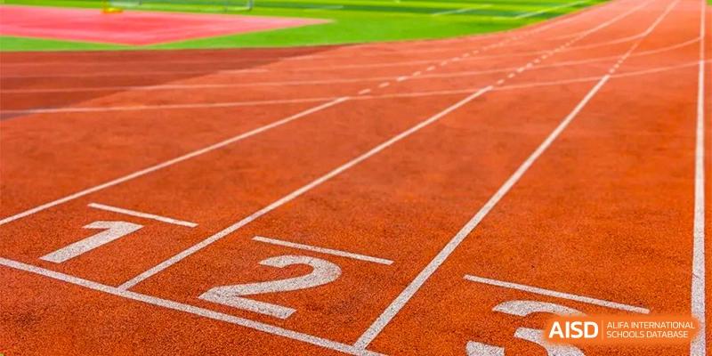 A close-up of the red running track with lane markings and the number 2 at the sports field of Wuhan Britain-China School.
