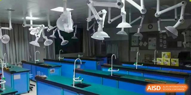 A bright, clean science laboratory with blue countertops, sinks, and specialized lighting fixtures, ready for class, at Ningxiang Country Garden School.