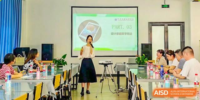 A female teacher giving a presentation or lecture, standing in front of a projector screen in a classroom, at Ningxiang Country Garden School.