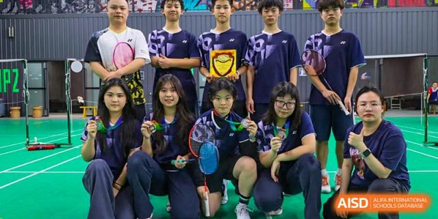 A group of male and female student athletes holding trophies and medals after a badminton competition at Changsha WES (Bilingual) Academy.