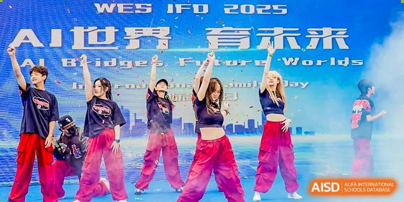 High school students performing a modern hip-hop dance on a stage with a large digital screen background that reads "IFD 2029" at Changsha WES (Bilingual) Academy.